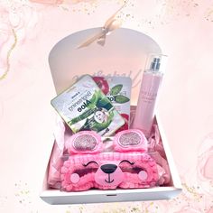 a pink teddy bear gift box with personal care items in it and flowers on the background