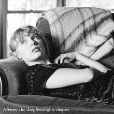 a woman laying on top of a couch next to a window