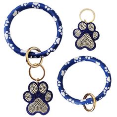 three different types of key chains with dogs paw prints on them, one is blue and the other has white polka dots