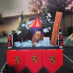 the back end of a red truck with a lion on it's flat bed