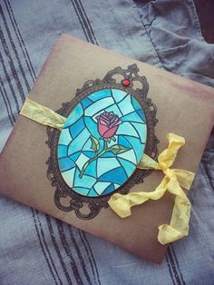 a stained glass card with a yellow ribbon on it and a rose in the middle