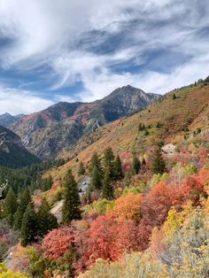 the mountains are covered in colorful foliage and trees with red, yellow, green, and orange leaves