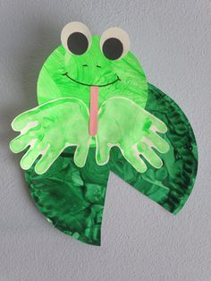 a paper plate with a green frog on it's face and tongue sticking out