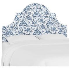 an upholstered headboard with blue and white floral designs on the top half