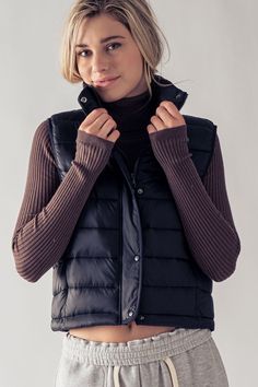 Stay warm and stylish in the Cozy Stride Quilted Puffer Vest. Designed with a trendy stripe-quilted pattern and a high stand collar, this vest is perfect for layering on those chilly days. Lightweight yet padded for extra warmth, it offers both comfort and fashion, whether you're out for a brisk walk or running weekend errands. The sleek silhouette and minimalist design make this vest a versatile addition to any wardrobe. Wear it over your favorite sweater or long-sleeve top for a casual, outdoo Trendy Outdoor Vest For Fall, Trendy Winter Vest For Cold Weather, Fall Turtleneck Vest For Layering, Turtleneck Vest For Fall Layering, Padded Collar Vest For Cold Weather In Fall, Fall Cold Weather Vest With Padded Collar, Fall Vest With Padded Collar For Cold Weather, Fitted Vest For Winter Layering, Winter Puffer Vest For Cold Weather