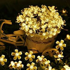 a basket full of yellow flowers sitting on the ground next to a bike and some lights