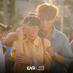 a man covering his eyes while holding a woman's head in front of him