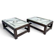 two tables with glass top sitting next to each other on a white surface and one is empty