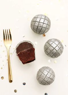 chocolate cake in an egg shell next to three silver eggs