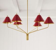 a red and gold chandelier hanging from the ceiling in a room with white walls