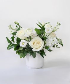 a white vase filled with flowers on top of a table