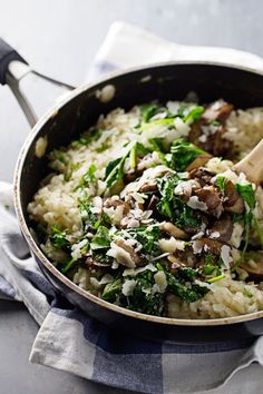 a pan filled with rice, mushrooms and spinach