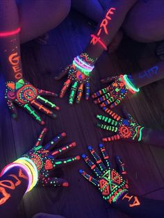 glow in the dark hands and fingers are arranged on a table with neon paint all over them