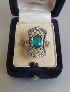 Art Deco emerald ring with diamonds, made of 14K gold and silver. With a Hungarian 14K hallmark that was used after 2016. The top part is made of silver. The head part of the ring is 0.796 inches (20 mm) long. Gemstone: one piece of emerald, 1.54 carat, its size is: 0.24 inches * 0.31 inches (6.1 mm * 7.8 mm) The emerald has inclusions which unfortunately affects the surface of the stone as well. I tried to make photos of that. Additional gemstone details: 20 single cut diamonds Carat weight: 0. Art Deco Emerald Ring With Rose Cut Diamonds, Art Deco Green Emerald Ring With Rose Cut Diamonds, Art Deco Emerald Jewelry With Rose Cut Diamonds, Emerald Ring With Rose Cut Diamonds For Formal Occasions, Art Deco Emerald Ring With Diamond Accents As Gift, Silver Emerald Ring With Diamond Accents, Victorian Style 14k Stamped Emerald Ring As Gift, Victorian 14k Stamped Emerald Ring As A Gift, Art Deco Emerald Ring With Diamond Accents