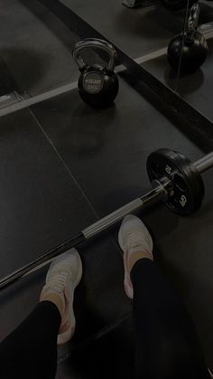 a person with their feet on a barbell