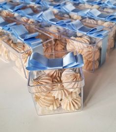 there are many cookies in plastic containers with blue bows on the top one is empty