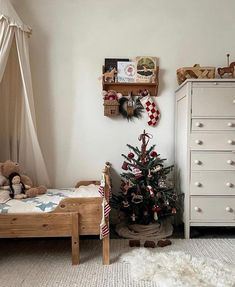 a bedroom with a christmas tree in the corner and stuffed animals on the floor next to it