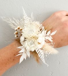 a woman's arm with white flowers and feathers on it