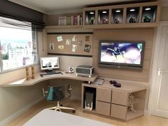 a computer desk with two monitors on top of it in front of a large window