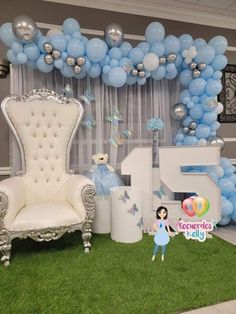 a balloon arch is decorated with blue and silver balloons for a princess themed birthday party