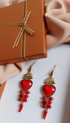 Religious earrings made of: - Enamelled Brass Sacred Heart (40 mm x 23 mm); - Smooth stones (6 mm), red color; - Brass italian horns; - Brass open hooks. Lenght : 8,5 cm / 3,35 inches * SHIPPING * Your order will be shipped within 1-3 business days from your purchase. You can choose between 2 shipping methods: STANDARD MAIL (NOT TRACEABLE) It is a cheap and fast shipping method, but NOT TRACEABLE. Chapeau Atelier is not responsible for any postal disruptions, delays or losses. REGISTERED MAIL (T Metal Jewelry With Ear Wire For Valentine's Day, Red Nickel-free Dangle Heart Earrings, Red Dangle Heart Earrings As A Gift, Nickel Free Red Earrings For Anniversary, Handmade Red Heart-shaped Jewelry, Red Dangle Heart Earrings For Gift, Nickel-free Red Earrings For Anniversary, Pierced Drop Earrings For Valentine's Day, Red Drop Heart Earrings For Wedding