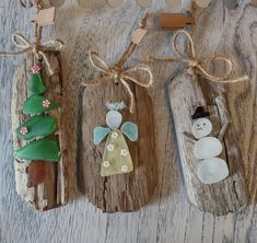 three wooden ornaments with snowmen and trees on them