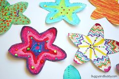 some colorful paper flowers are on a white surface