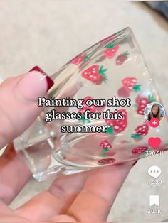 someone is holding a glass with strawberries on it and the caption reads, painting our shot glasses for this summer