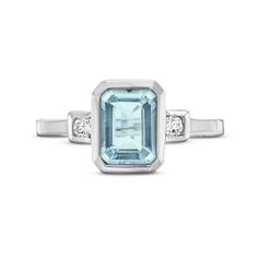 This Aquamarine Diamond Bezel Ring features an emerald cut aquamarine weighing approimately 1.60 carats accented with 0.08 carats of round brilliant cut diamonds on each side. Blue Topaz Ring With Emerald Cut And Bezel Setting, Emerald Cut Blue Topaz Birthstone Ring With Accent Stones, Blue Topaz Emerald Cut Ring With Bezel Setting, Emerald Cut Blue Topaz Ring With Bezel Setting, Emerald Cut Topaz Ring With Diamond And Gemstone Accents, Emerald Cut Blue Topaz Diamond Ring, Emerald Cut Aquamarine Rings With Gemstone Accents, Emerald Cut Light Blue Topaz Ring With Accent Stones, Light Blue Emerald-cut Topaz Ring With Accent Stones