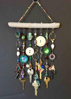 a wall hanging with several different types of buttons and key chains attached to the hooks