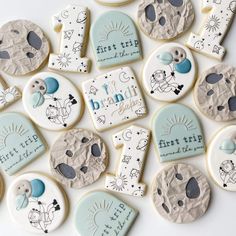 baby cookies decorated in blue and white with the words first trip written on them are laid out next to each other