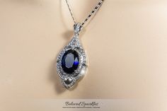 Adela Vintage Art Deco Sapphire Blue 27 Carat Oval Pendant Necklace. This gorgeous 27 Carat Vintage Art Deco Pendant Style is created with best quality 16 Sapphire Blue Oval Cut Crystal Center Stone, Accented by Clear Pave Cubic Zirconia and 18.5 Inch plus Extender Link Chain and Polished into a Lustrous Silvertone Finish. This is a vintage timeless piece will pair beautifully with your event attire. Item# BSA-PZT1814PRUBY Color: Silver Gemstone: Grade AAA Cubic Zirconia, Swarovski Crystal Total Oval Pendant Necklace, Art Deco Pendant, Blue Pendant, Sapphire Pendant, Oval Pendant, Cz Diamond, Sapphire Blue, Ruby Red, Vintage Art Deco