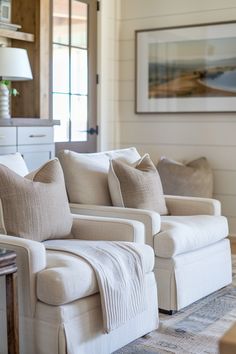 Elegant and cozy farmhouse living room chairs with neutral upholstery and accent pillows, capturing modern farmhouse charm.