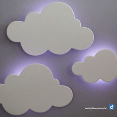 three white clouds are lit up on the wall