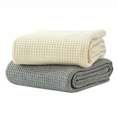 two blankets stacked on top of each other in grey and white colors, one is folded over the other