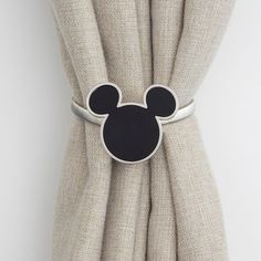 a mickey mouse head is attached to the curtain in front of a beige drapes