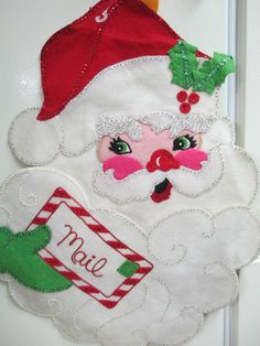 a door hanger with a santa clause on it's face and name tag