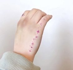 a woman's hand with pink stars on it