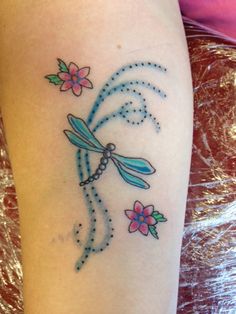 a woman's arm with a dragonfly tattoo on it