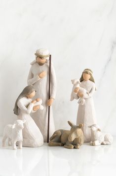 three figurines of people and animals on a marble surface