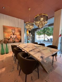 a dining room table with chairs and chandelier hanging from the ceiling