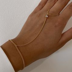 Level up your summer accessory game with out Brody CZ Hand Chain! This hand chain features a dainty curb chain and stunning CZ stone for the perfect mix of edgy and glam. Trust us when we say this is a MUST have for your summer wardrobe! Product Details 14K Gold filled basic chain 14K CZ Stones 6", 7", 8" lengths available 3.5" connecting chain Size 12 Ring Opening Adjustable Metal Jewelry With Curb Chain, Metal Curb Chain Jewelry For Party, Adjustable Metal Curb Chain Jewelry, Elegant Double Chain Bracelet For Party, Trendy Adjustable Body Jewelry With Adjustable Chain, Elegant Curb Chain Jewelry For Parties, Elegant Party Jewelry With Curb Chain, Gold Plated Chain Link Jewelry With Chain Strap, Trendy Curb Chain Jewelry For Parties