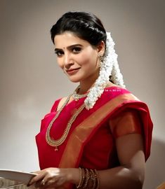 a woman in a red sari holding a plate