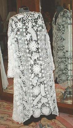 a white lace dress on display in front of a mirror