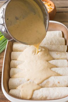 someone pouring sauce on some pita bread in a pan with asparagus and celery