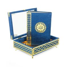 an open blue box with gold trimmings and arabic writing on the lid, sitting on a white surface