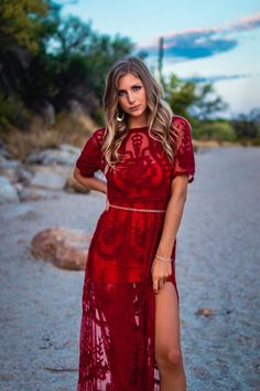 a beautiful woman in a red dress posing for the camera