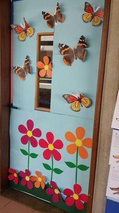 a door decorated with butterflies and flowers on the outside, in front of a blue wall