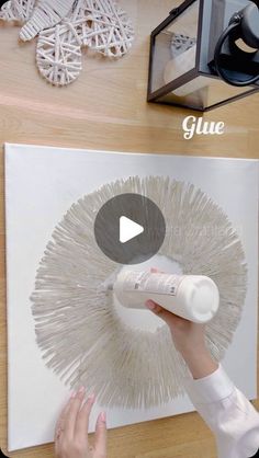 a person is using glue to decorate a piece of art