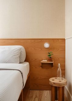 a bedroom with two beds and a small table in the corner next to it on top of a hard wood floor